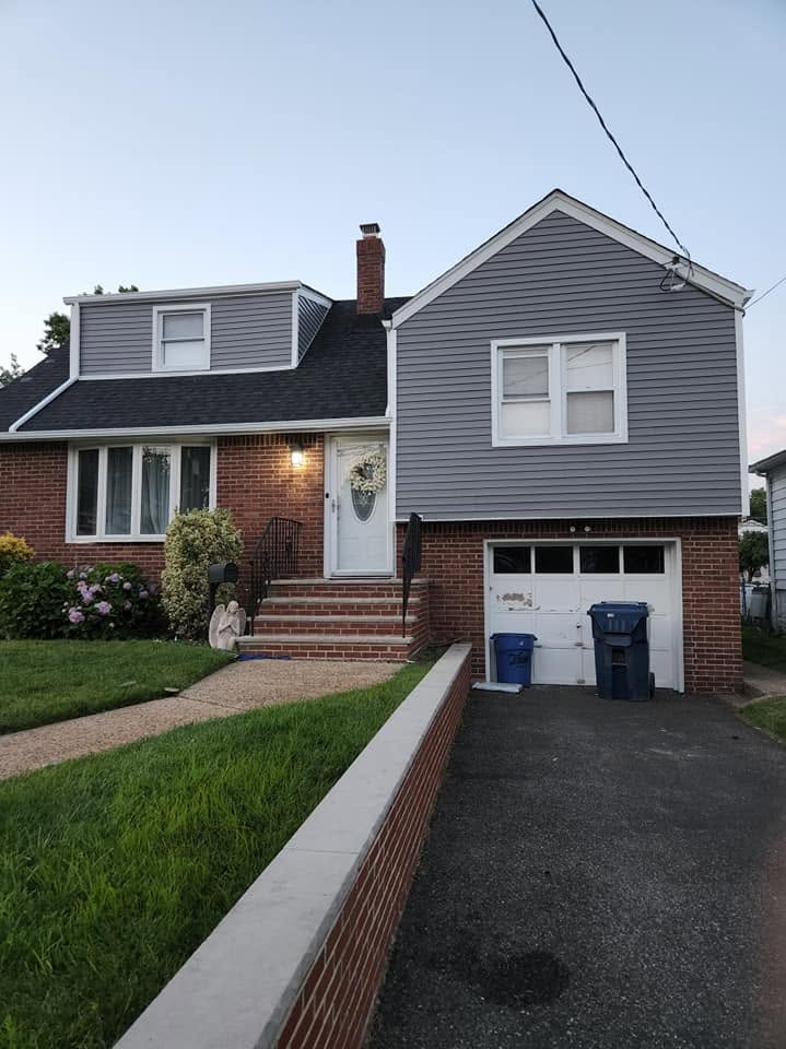 Split-level home with new gray siding and brick facade