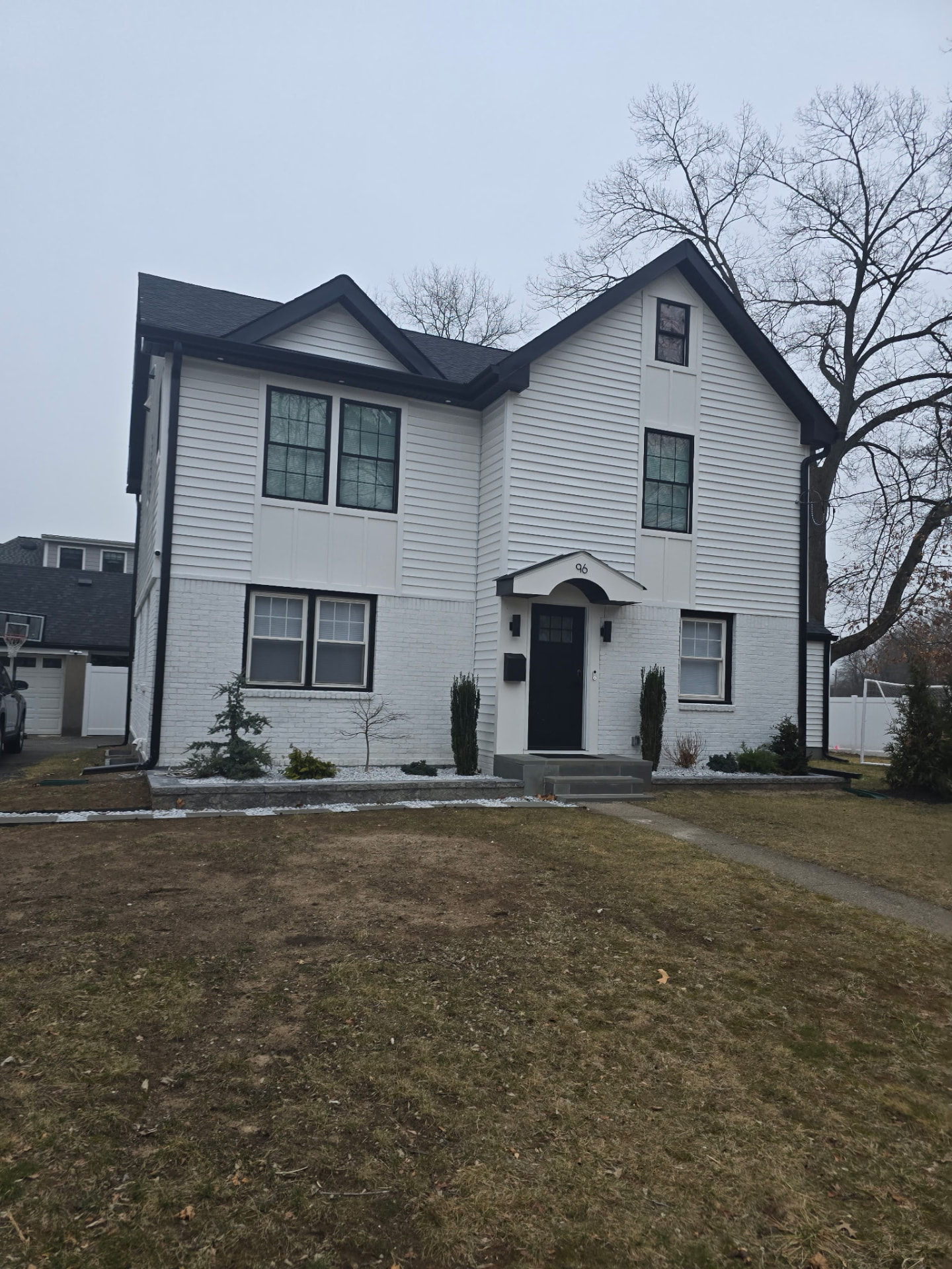 White colonial home with black trim and new entry